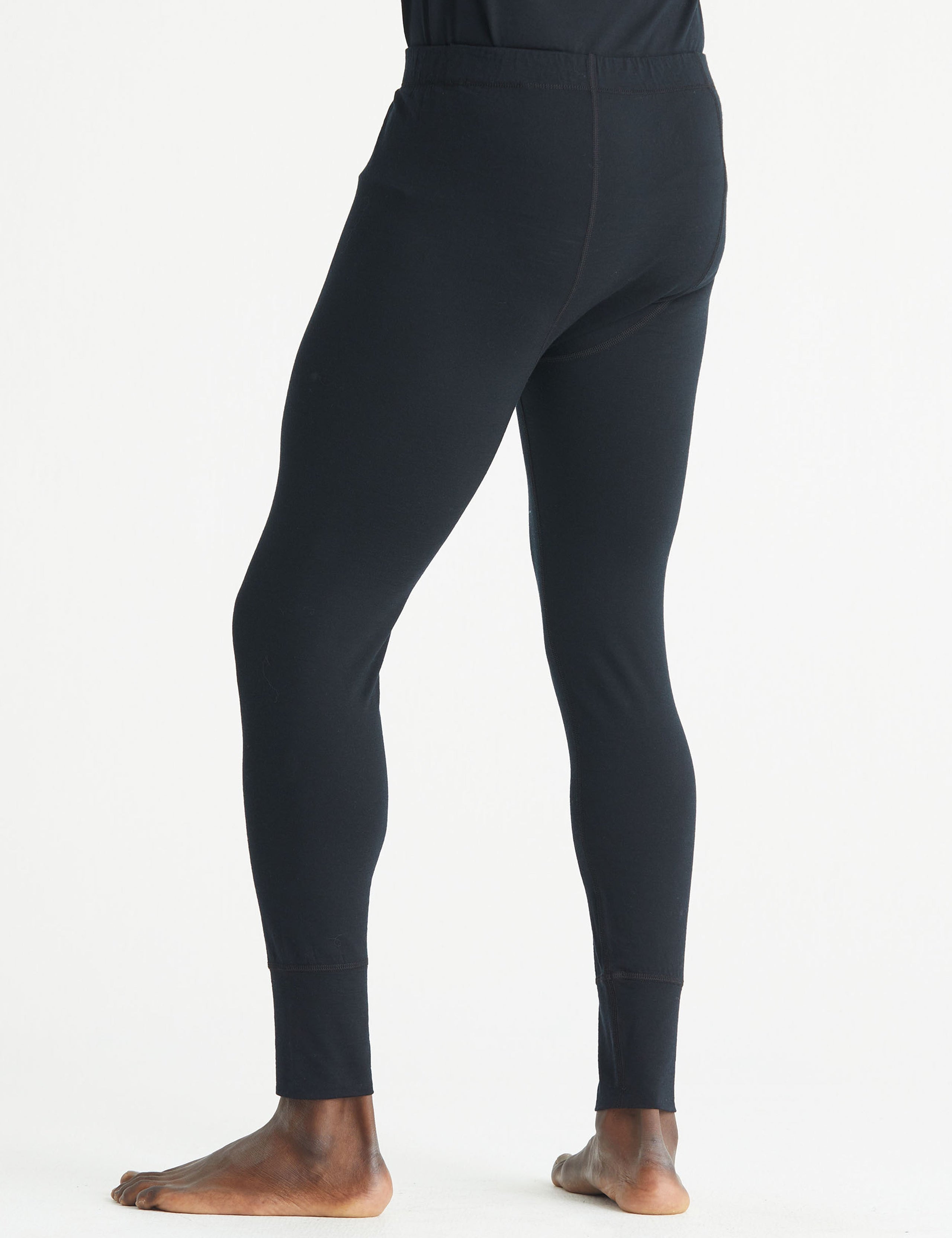 Rear 3/4 lower body view of man wearing Premium Merino Base Layer Pant in Jet Black from AETHER Apparel.
