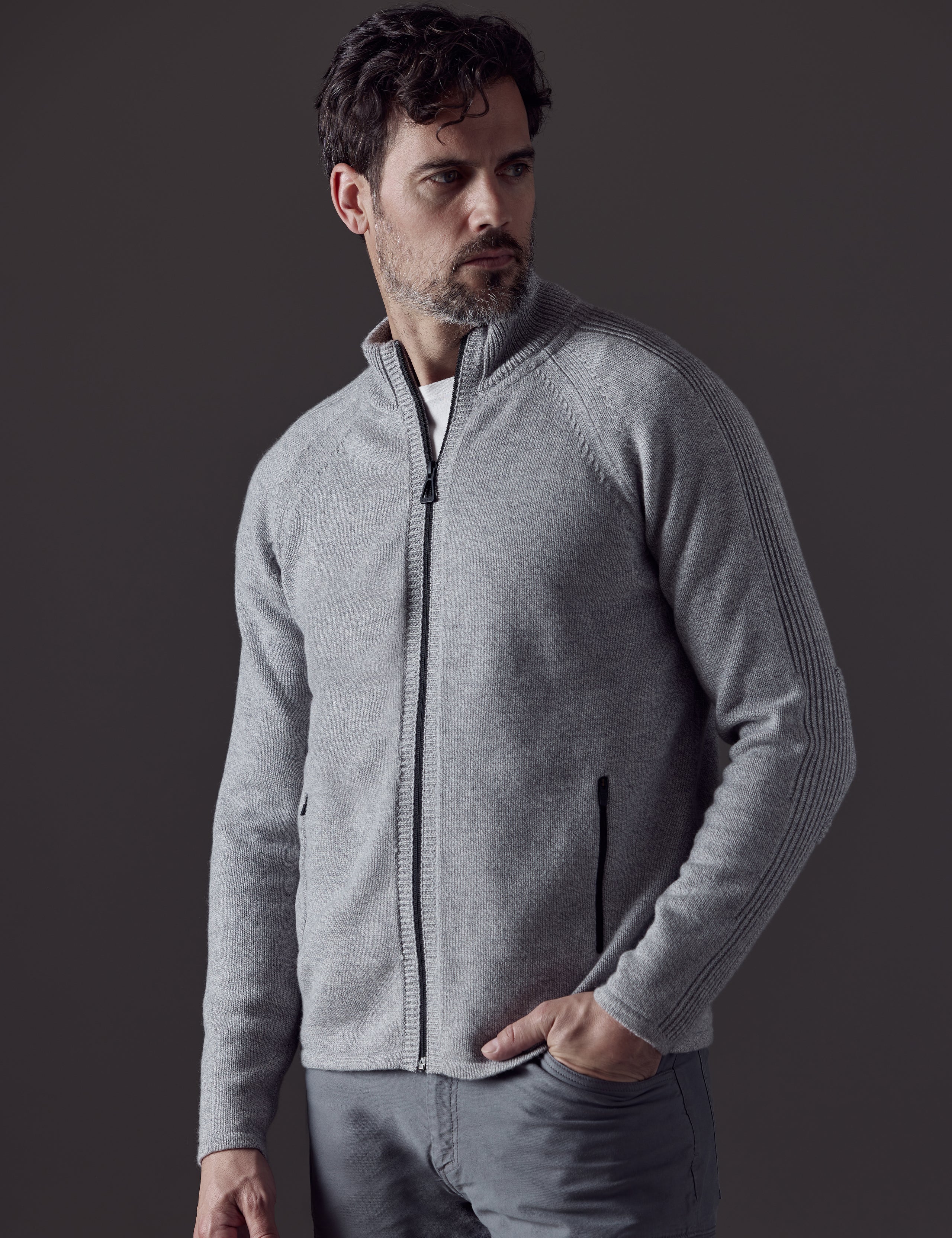 Front 3/4 body view of man looking over shoulder wearing Riley Full-Zip Sweater in Light Heather Grey from AETHER Apparel.