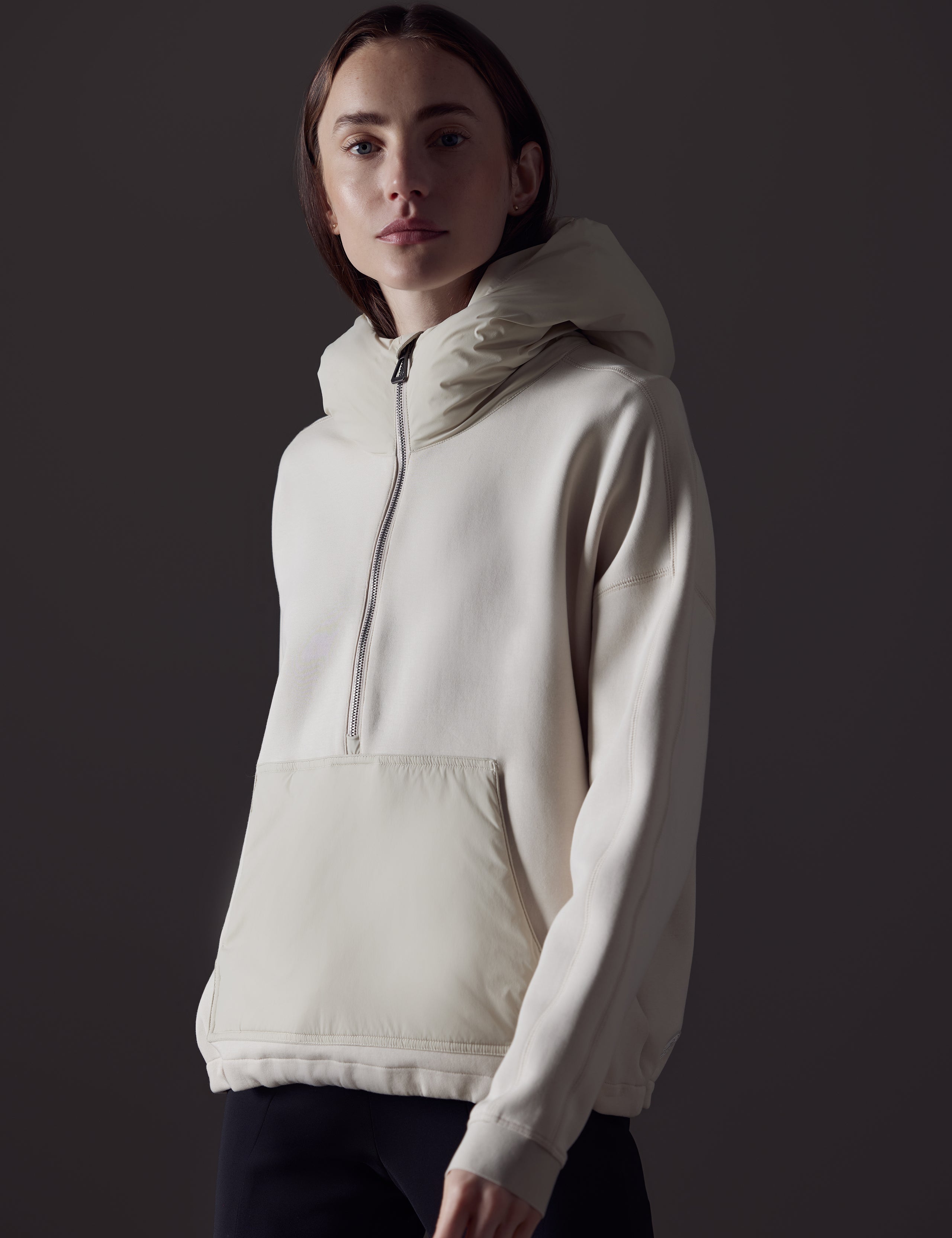 Front angled view of woman wearing Align Hooded Anorak in Bone white from AETHER Apparel.