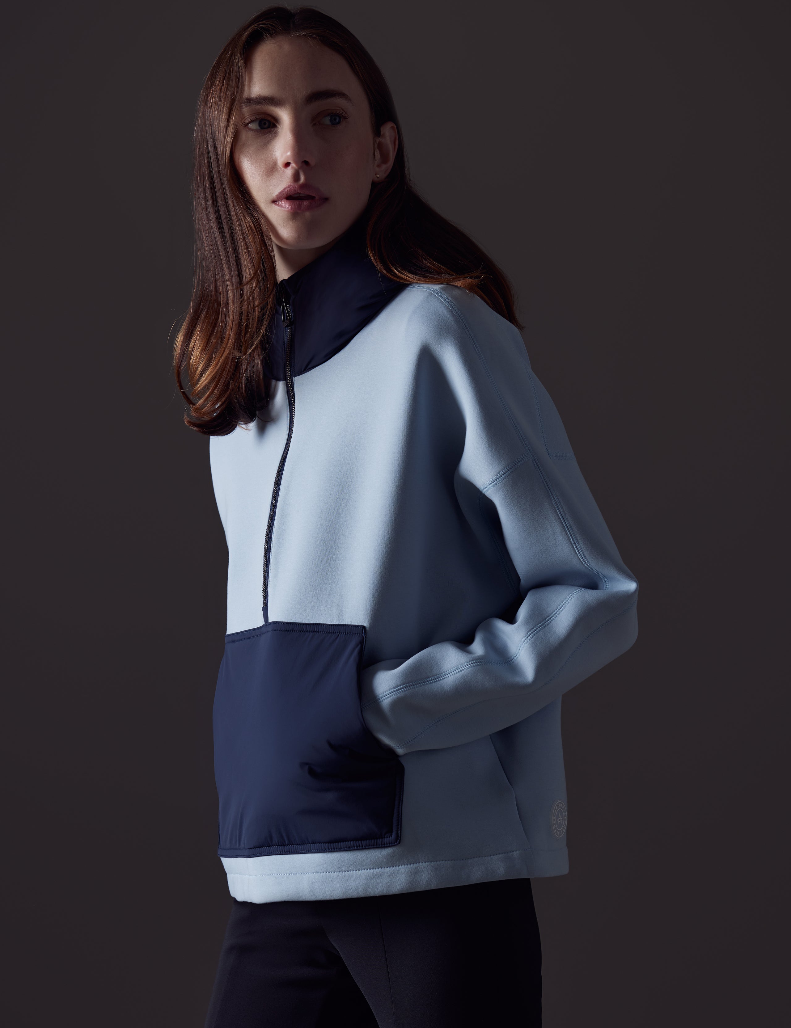 Front angled view of woman wearing Align Hooded Anorak in Flight Blue from AETHER Apparel.