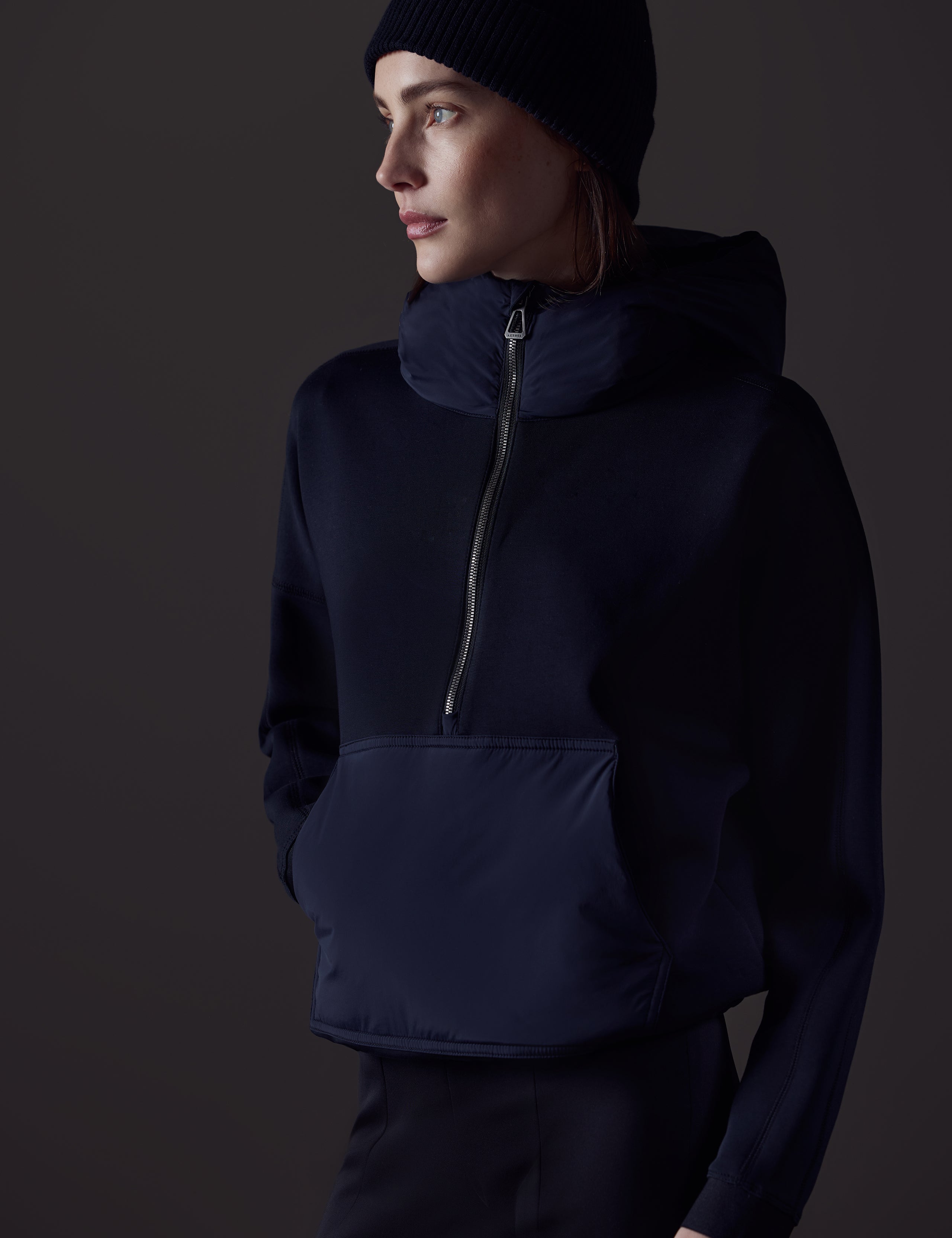 Front angled view of woman wearing Align Hooded Anorak in Onyx Black from AETHER Apparel.