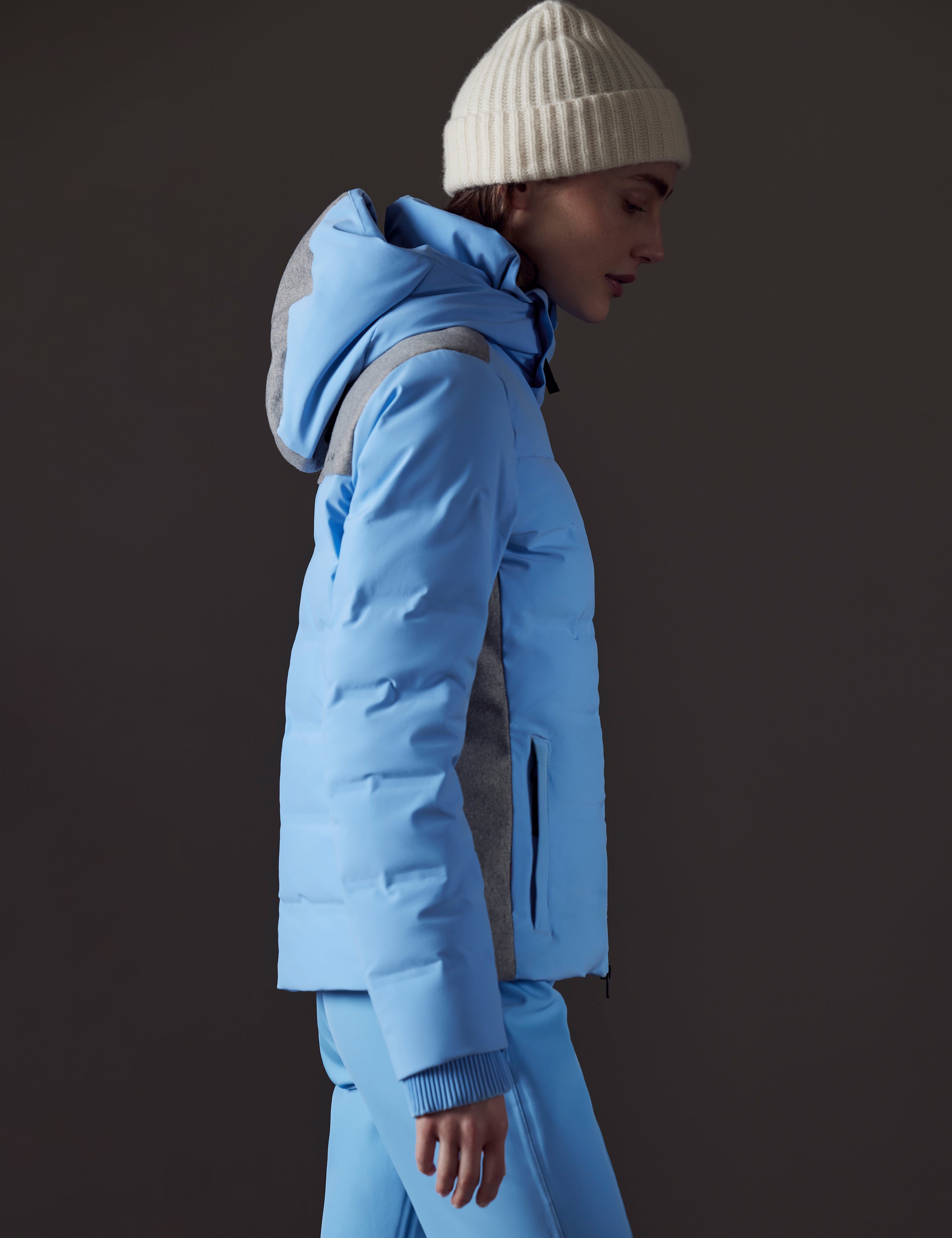 Side profile view of woman wearing Bancroft Snow Jacket in Atlas Blue from AETHER Apparel.