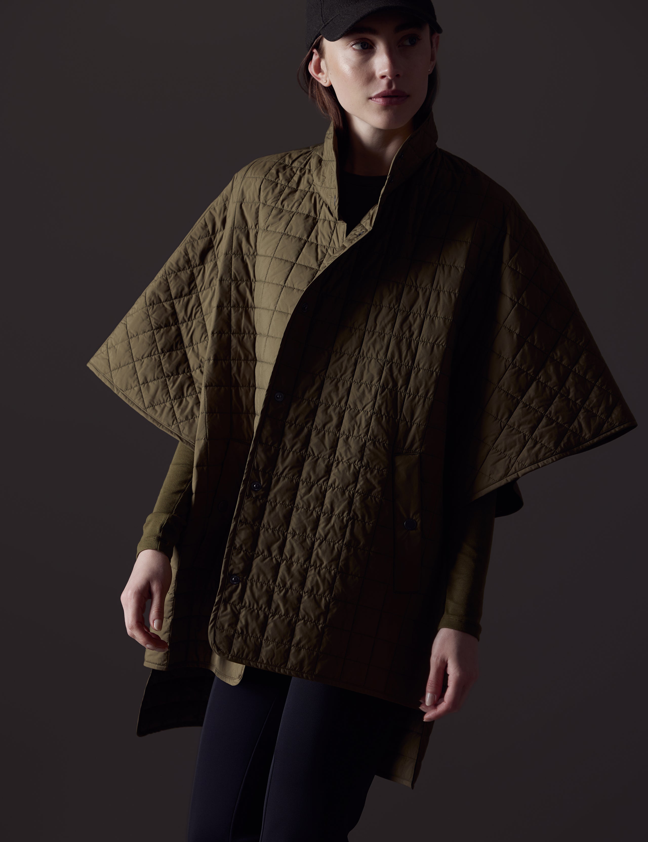 Front body view of woman wearing Bardo Poncho Jacket in Command Green from AETHER Apparel.