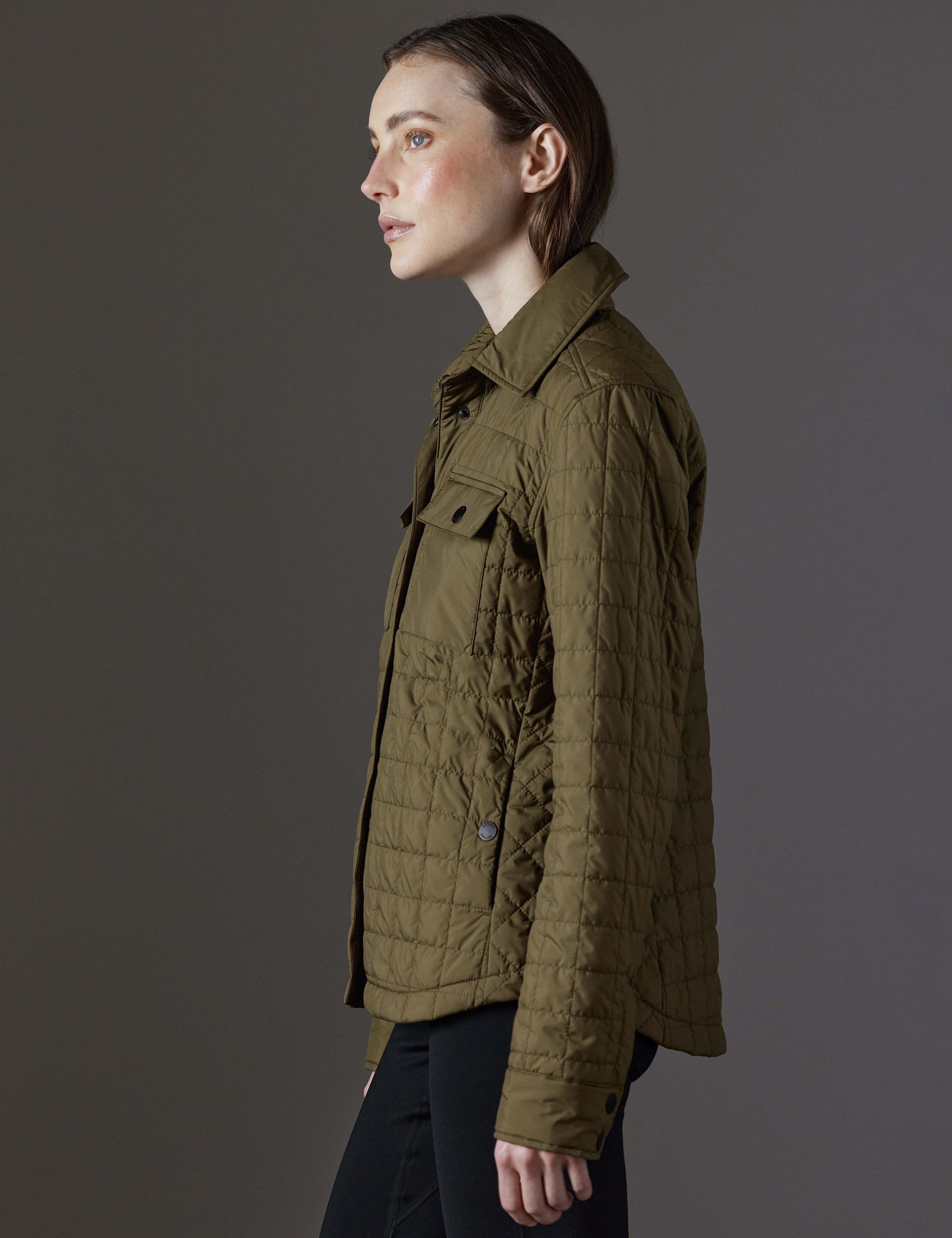 Side profile view of woman wearing Bardo Shirt Jacket in Command Green from AETHER Apparel.