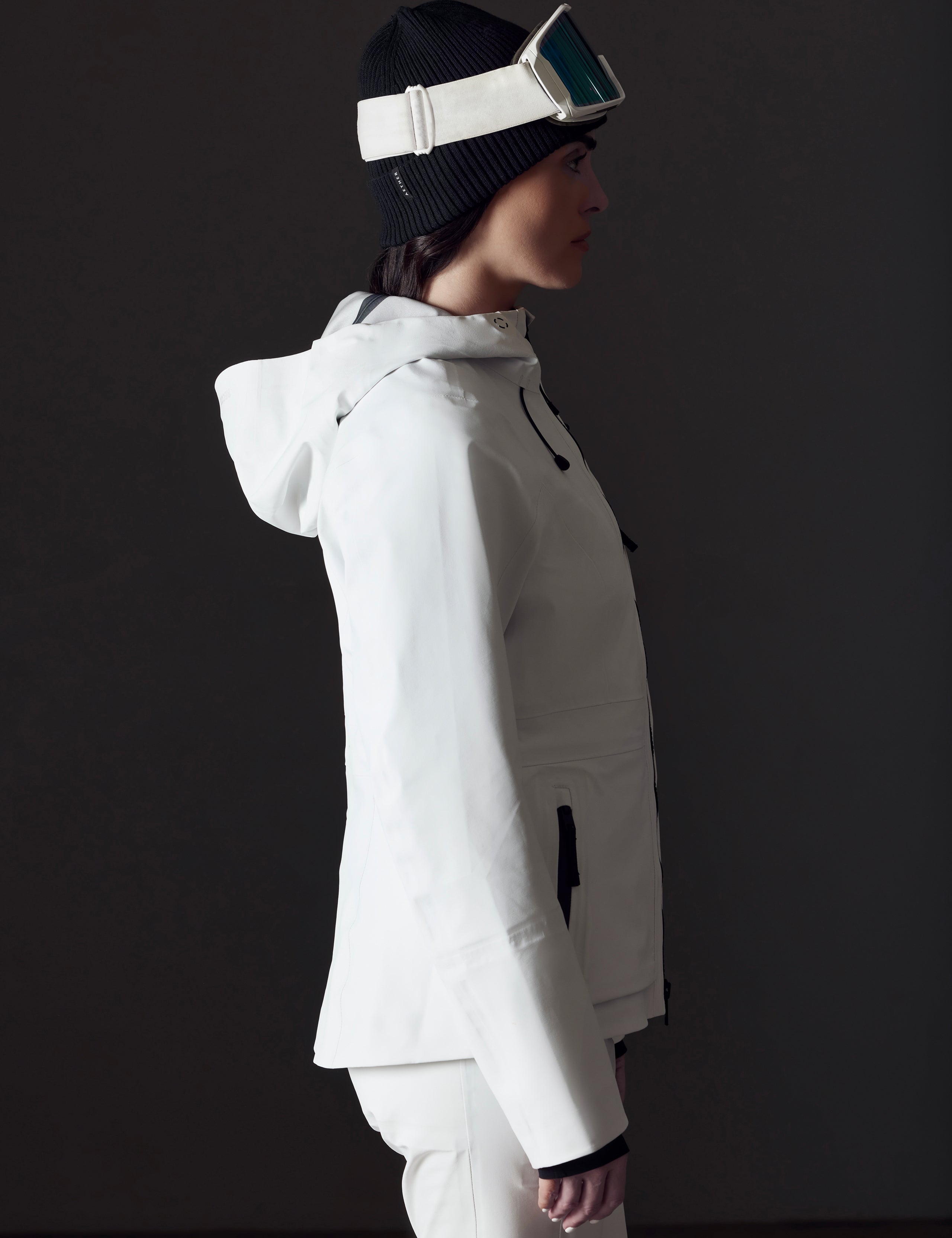 Side profile view of woman wearing Boyd Snow Jacket in White from AETHER Apparel.