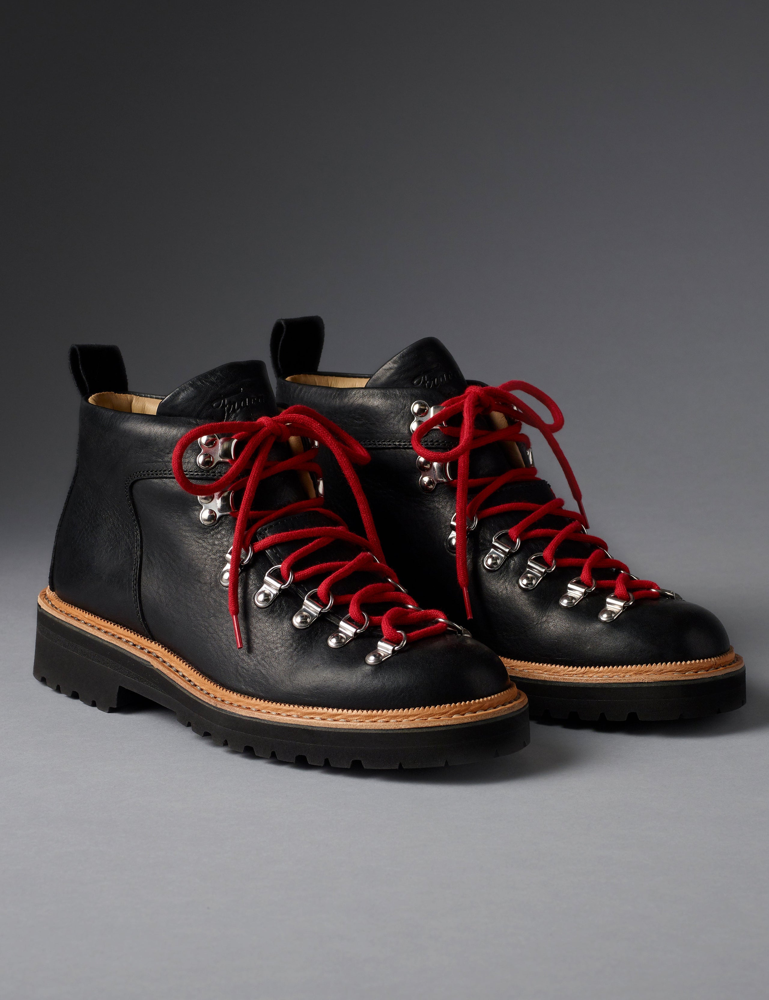 Front angled view of women’s Dolomite Boot in Onyx Black from AETHER Apparel with red laces. 