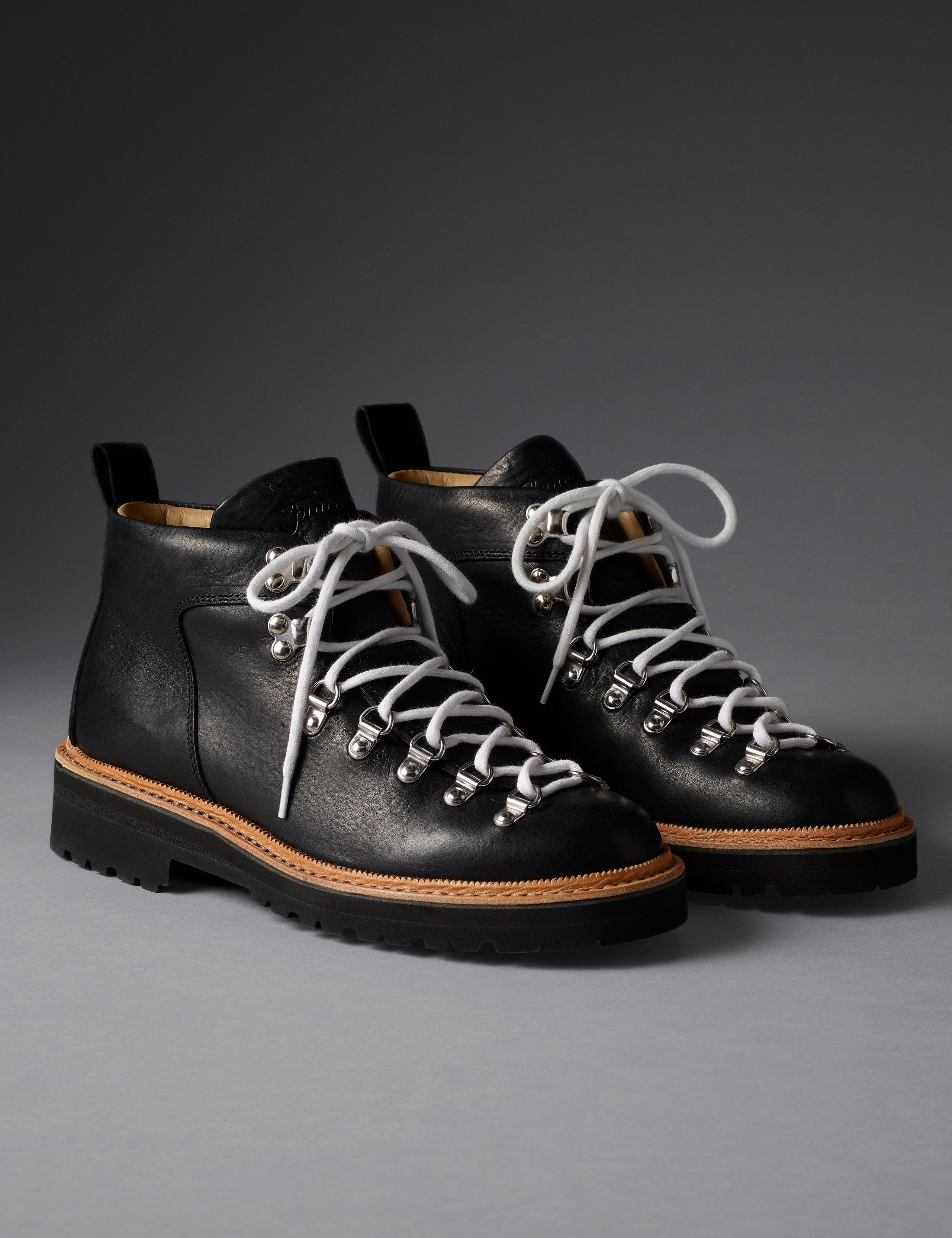 Front angled view of women’s Dolomite Boot in Onyx Black from AETHER Apparel with white laces. 