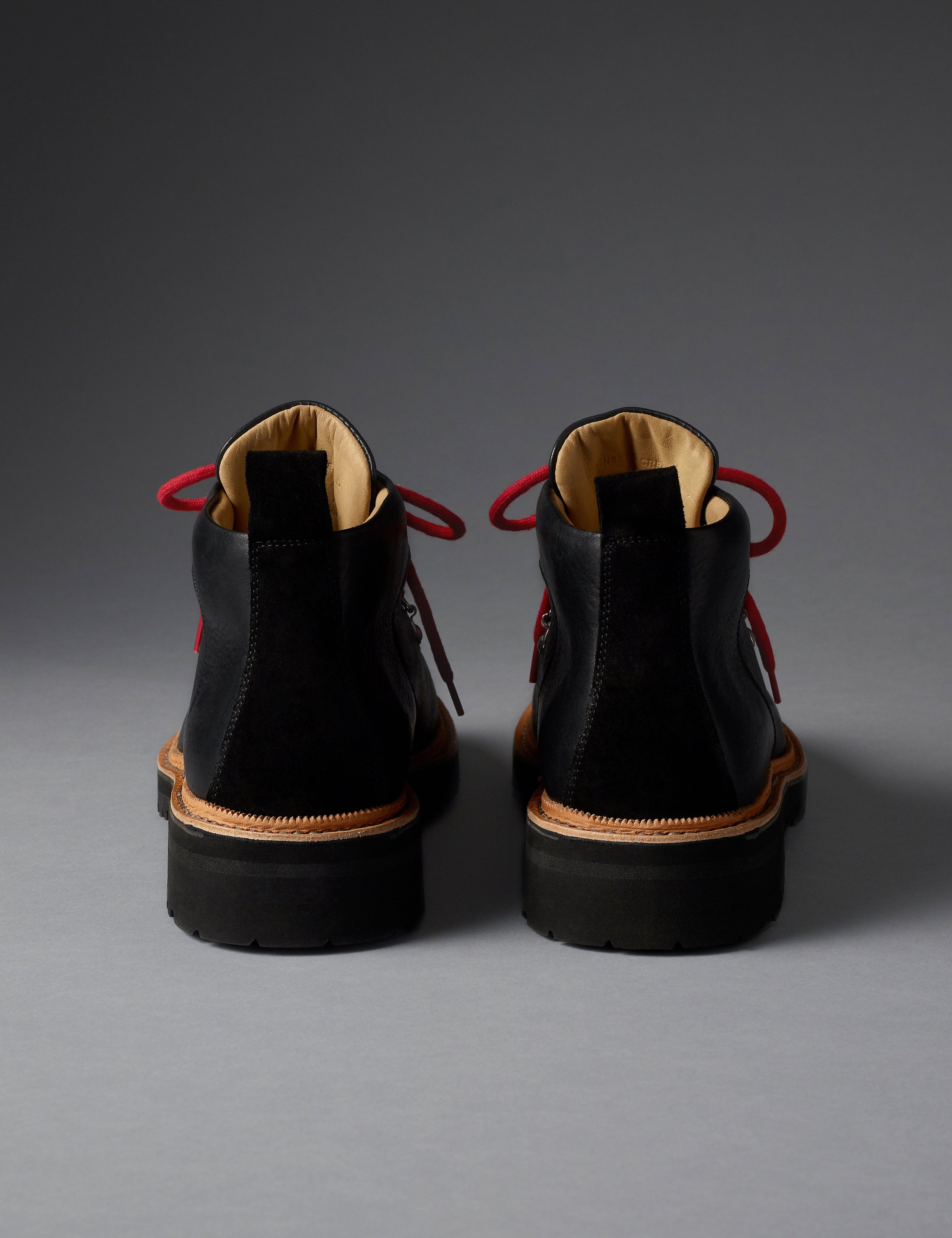 Rear view of women’s Dolomite Boot in Onyx Black from AETHER Apparel with red laces. 
