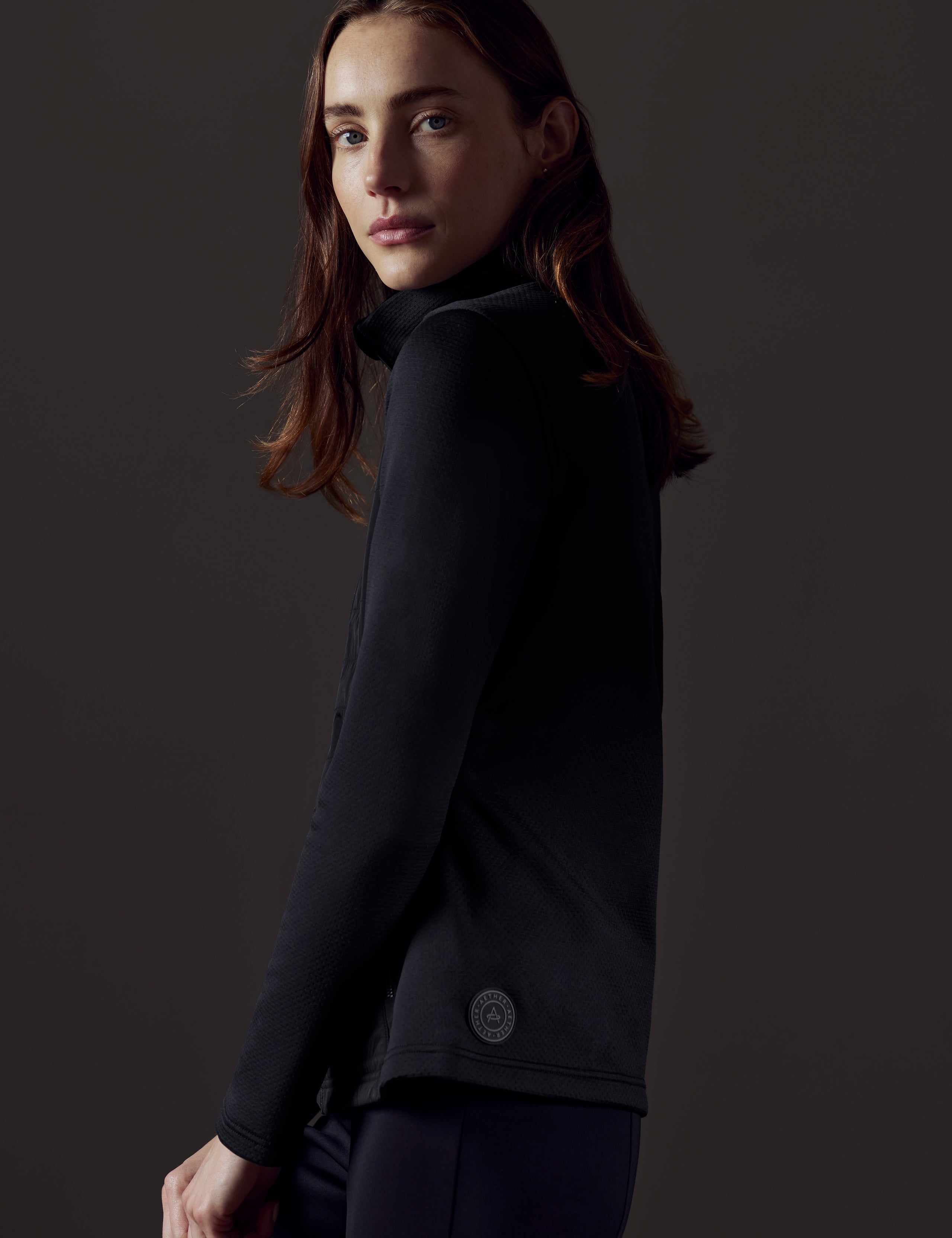 Side profile view of woman wearing Morgan Technical Full-Zip in Onyx Black from AETHER Apparel.