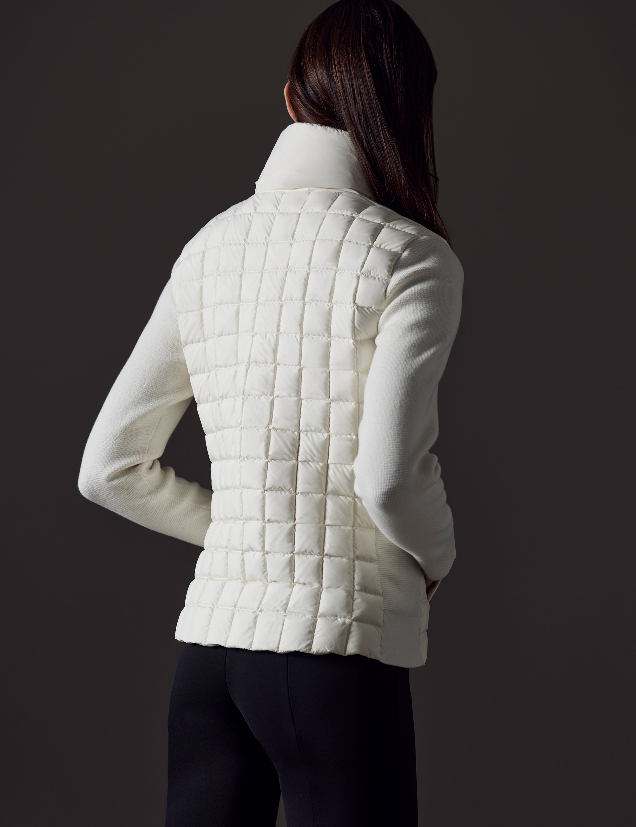 Rear angled view of woman wearing Phase Full-Zip in Winter White from AETHER Apparel.