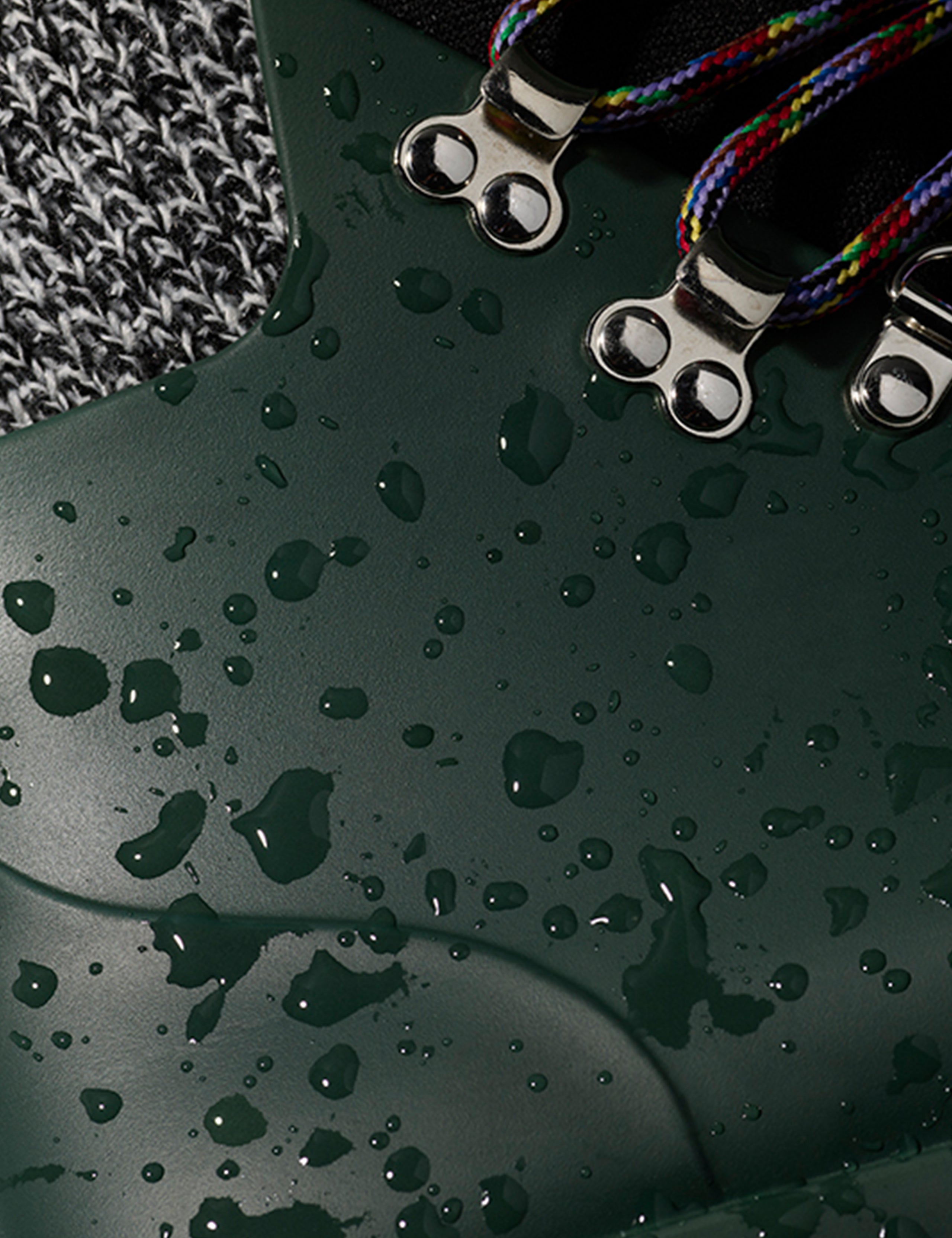 Closeup detailed view of metal speed lacing hooks and weatherproof uppers on women's Rain Boot in Dark Green from AETHER Apparel. 