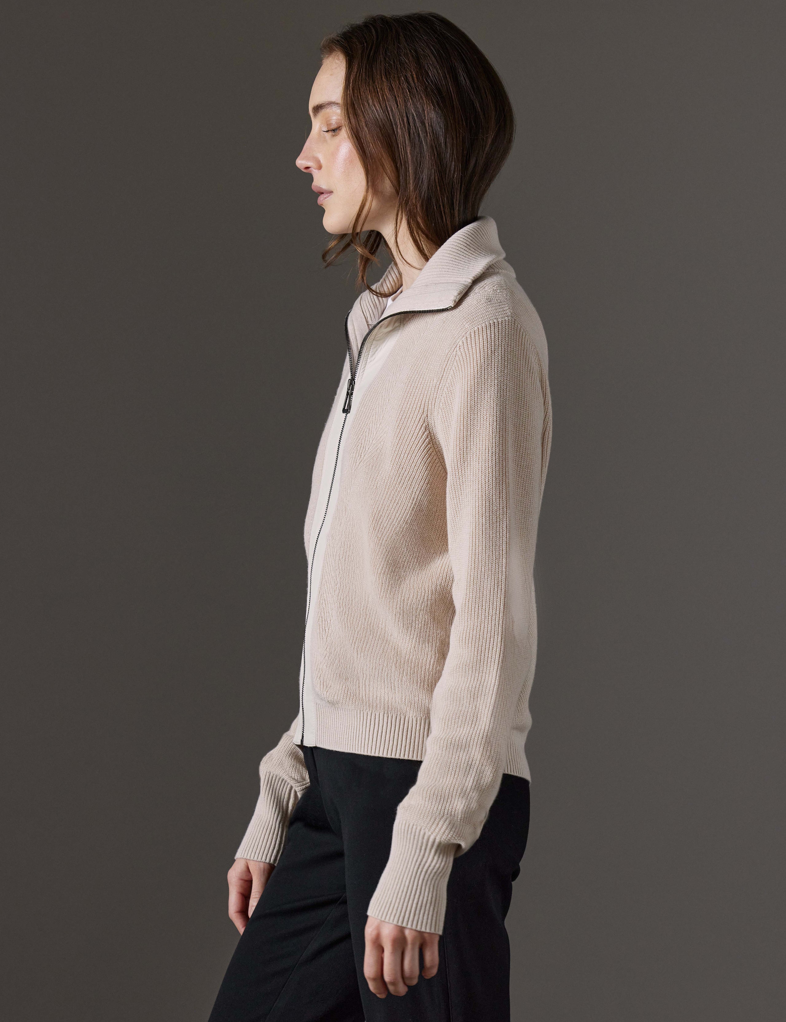 Side profile view of woman wearing Rhea Full-Zip Sweater in Bone white from AETHER Apparel.