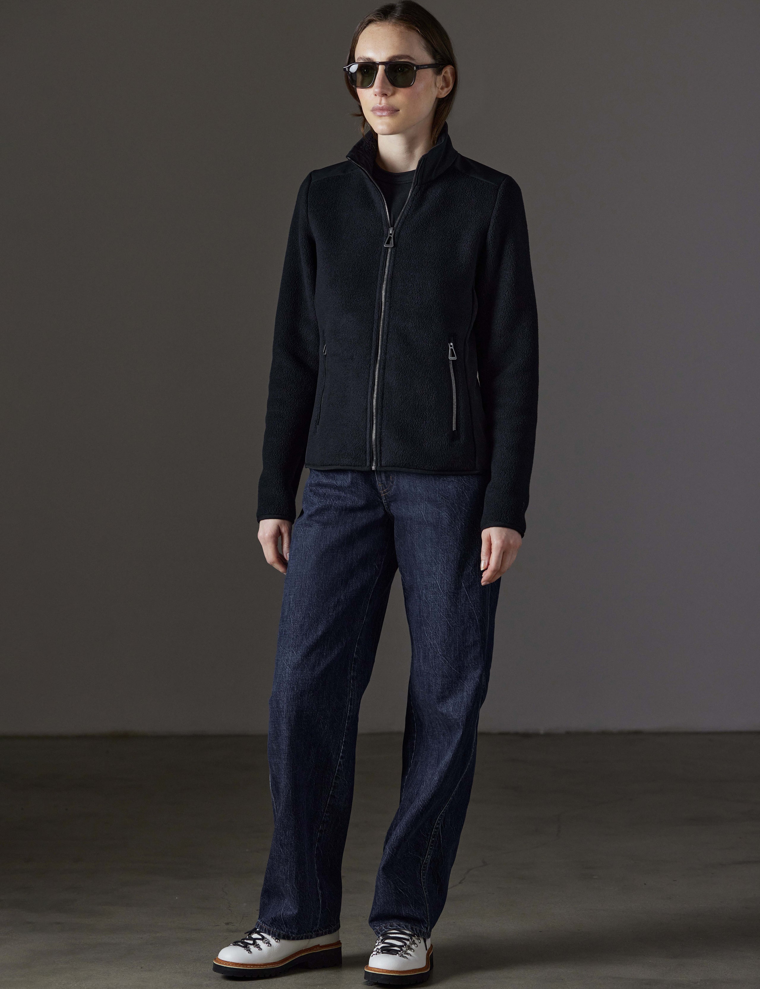 Front angled full-body view of woman wearing Walsh Full-Zip 2.0 in Onyx Black from AETHER Apparel.