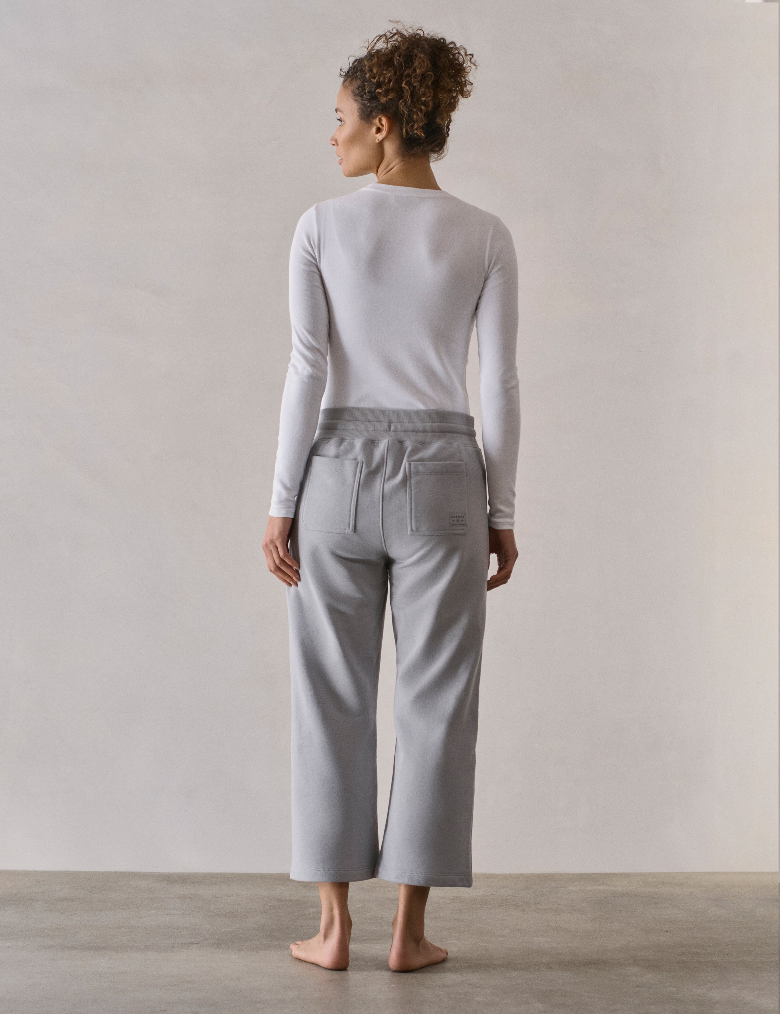 Rear full-body view of woman wearing W Osa Cropped Sweatpant in Sky Grey from AETHER Apparel.